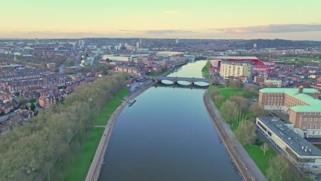 A-flight-along-the-River-Trent,-whose-still-water-reflects-the-late-sunset-sky