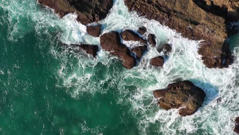 Top-View-Of-Sea-Waves-Crashing-Against-Rocks