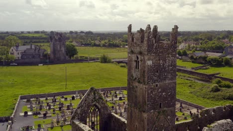 Claregalway-Friary-tower-telephoto-parallax-rises-past-cemetery-tombstones-on-grounds