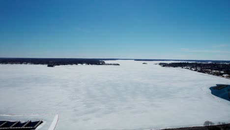 Drone-aerial-view-of-frozen-Lake-Minnetonka-on-a-sunny-day-in-the-winter