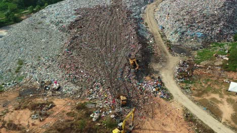 Drone-flyover-a-massive-abandoned-sanitary-landfill-with-large-piles-of-unsorted-solid-wastes-in-the-illegal-dump-site,-concept-of-environmental-sustainability,-global-warming,-climate-change