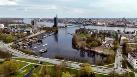 Aerial-Drone-Fly-Zunds-river-landscape,-street-traffic-at-Latvia-Riga-Capital-city