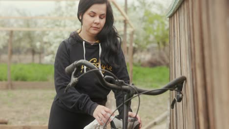 Woman-Wiping-And-Cleaning-Her-Bicycle-Outdoors---Medium-Shot