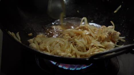 Stir-frying-onions-and-chicken-in-a-hot-wok-on-high-heat-for-a-delicious-meal