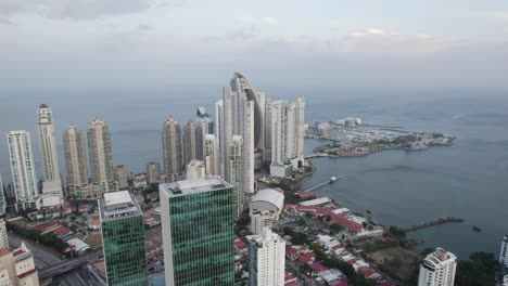 Punta-Pacífica-En-La-Ciudad-De-Panamá-Con-Edificios-De-Gran-Altura-Y-El-Océano-Al-Fondo,-Vista-Aérea