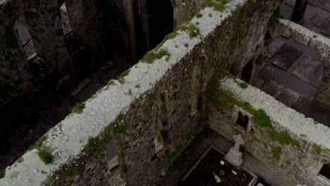 Cemetery-plots-and-tombstones-in-Claregalway-Friary-monastery-grown-decrepit-and-overgrown-towers