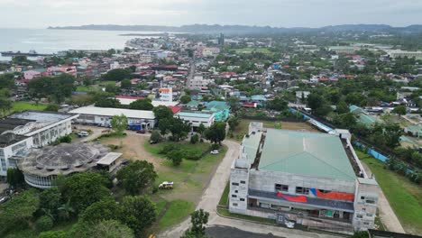 Aerial-view-of-stadium-building-under-construction-and-island-provincial-town-with-lush-foliage-in-Catanduanes,-Philippines