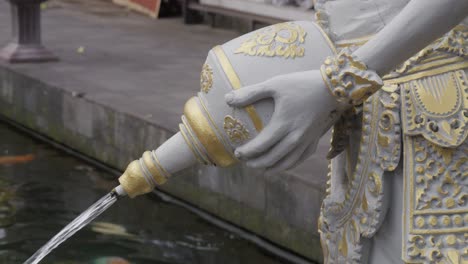 Close-up-of-an-ornate-statue-pouring-water-in-Pura-Gunung-Kawi-Sebatu-Temple-in-Bali,-Indonesia