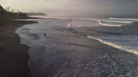 Balian-surfers-beach-with-solo-silhouetted-surfer-walking-out-to-catch-some-tranquil-waves