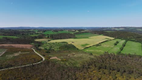 Panoramic-View-Over-Countryside-Landscape-With-Tractor-Working-On-Agricultural-Field---Drone-Shot