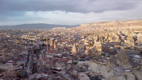 Aerial-Drone-View-of-Goreme-Turkey,-Edge-of-City-Limits:-Scenic-Town-Nestled-in-the-Heart-of-Cappadocia's-Unique-Rock-Formations---Fairy-Chimney-House:-Downtown-Göreme,-Nevşehir-Türkiye