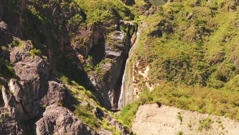 Bird's-eye-view-of-a-beautiful-waterfall-cascading-down-a-rocky-and-green-mountain-in-Jujuy,-in-the-northwest-of-Argentina