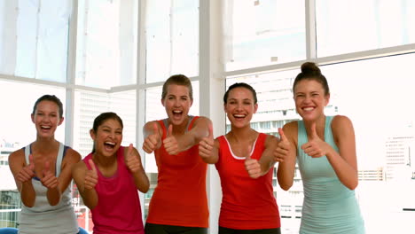 Fitness-class-smiling-at-camera-showing-thumbs-up