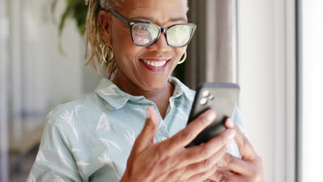 African-American-senior-woman-holding-smartphone,-smiling