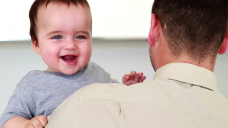 Father-holding-his-happy-baby-boy-before-work