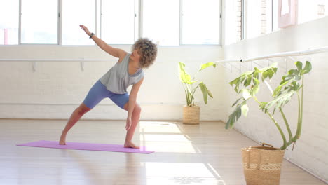 Biracial-Junge-Frau-Praktizieren-Yoga-In-Hellen-Studio