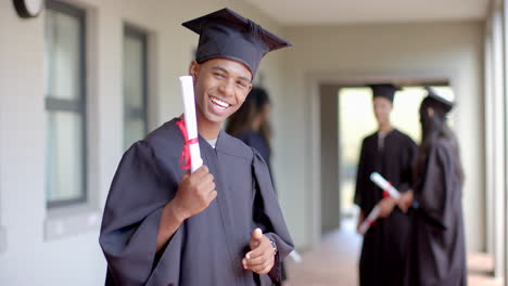 Biracial-teenage-boy-celebrates-graduation-at-high-school