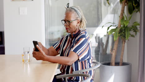 A-senior-African-American-woman-is-using-smartphone-at-home
