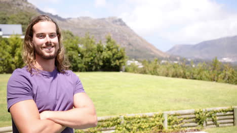 A-young-Caucasian-male-stands-with-arms-crossed-outdoors,-copy-space