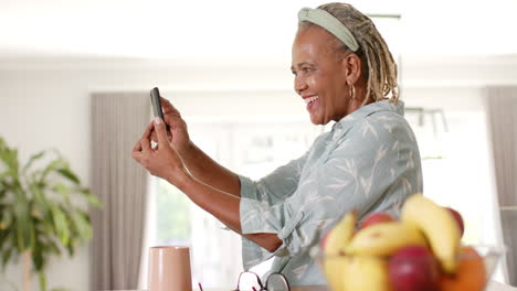 A-senior-African-American-woman-is-using-her-smartphone-at-home