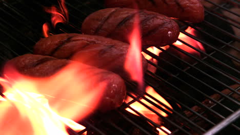 Sausages-being-cooked-on-flaming-barbecue