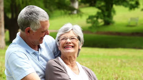 Affectionate-senior-couple-relaxing-in-the-park-