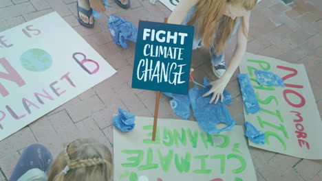 Animation-of-fight-climate-change-placard-over-diverse-children-making-ecology-protest-banners