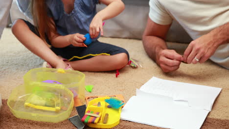 Happy-siblings-doing-arts-and-crafts-on-the-rug-with-parents