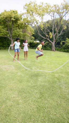 Vertical-video:-Diverse-family-playing-jump-rope-outside