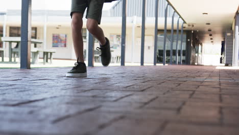 In-a-school-corridor,-a-young-Caucasian-student-walks-away-with-copy-space