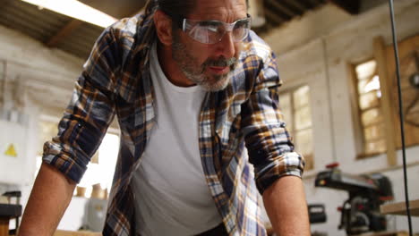 Carpenter-smiling-for-camera-while-reading-plan