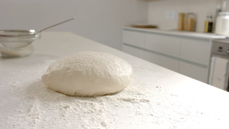 Fresh-dough-sits-on-floured-surface-in-a-bright-kitchen