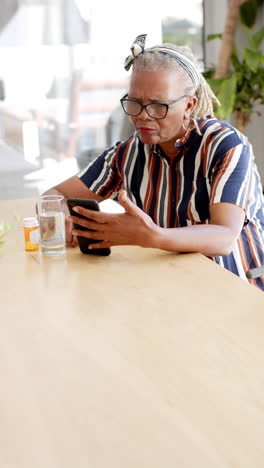 Video:-Elderly-Black-woman-in-glasses-views-phone-vertically