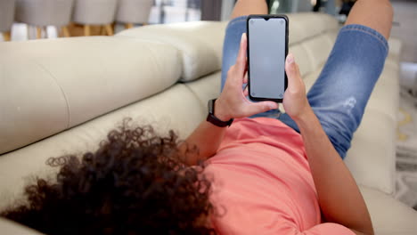 A-young-biracial-man-is-lounging-on-a-sofa