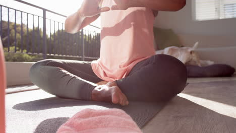 A-senior-African-American-woman-sitting-cross-legged,-practicing-yoga