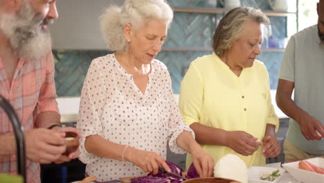 Group-of-senior-friends-preparing-food-together-in-kitchen