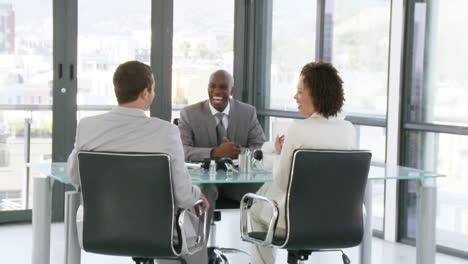 Three-successful-people-talking-about-bussiness-on-a-desk