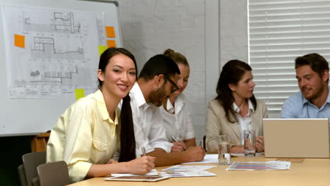 Casual-businesswoman-smiling-at-camera-during-meeting