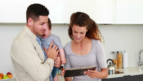 Eltern-Benutzen-Tablet-PC,-Während-Vater-Baby-Hält