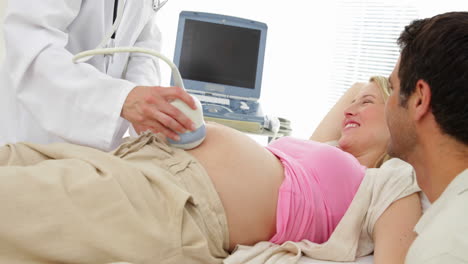 Blonde-pregnant-woman-having-a-sonogram-scan-with-her-partner