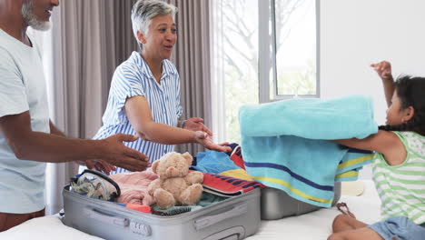 Diverse-grandparents-are-packing-with-their-granddaughter
