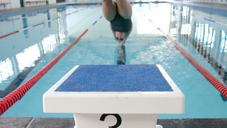 Ein-Schwimmer-Bereitet-Sich-Auf-Den-Sprung-Vom-Startblock-Vor,-Blauer-Hintergrund