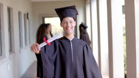 Proud-teenage-biracial-boy-celebrates-graduation-at-high-school