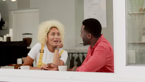 Una-Feliz-Pareja-De-Mujeres-Birraciales-Y-Hombres-Afroamericanos-Comparten-Un-Momento-Tomando-Un-Café