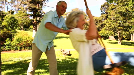 Retired-man-pushing-his-wife-on-swing