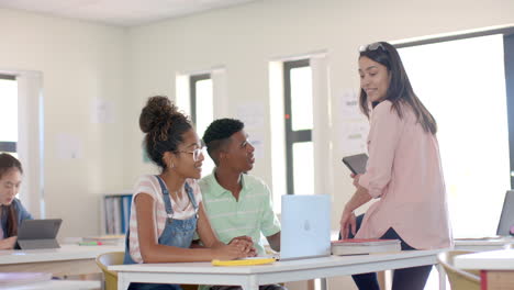 Diverse-high-school-students-engage-with-teacher-in-a-bright-classroom