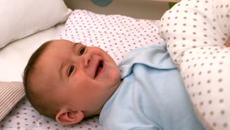 Baby-playing-with-blanket-in-his-crib