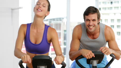 Colocar-Pareja-Haciendo-Ejercicio-En-Bicicleta-En-El-Gimnasio