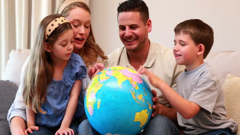 Feliz-Familia-Joven-Sentada-En-El-Sofá-Mirando-El-Globo