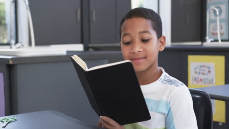 In-school,-in-the-classroom,-a-young-African-American-student-reads-a-book